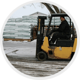 a man is driving a forklift in the snow