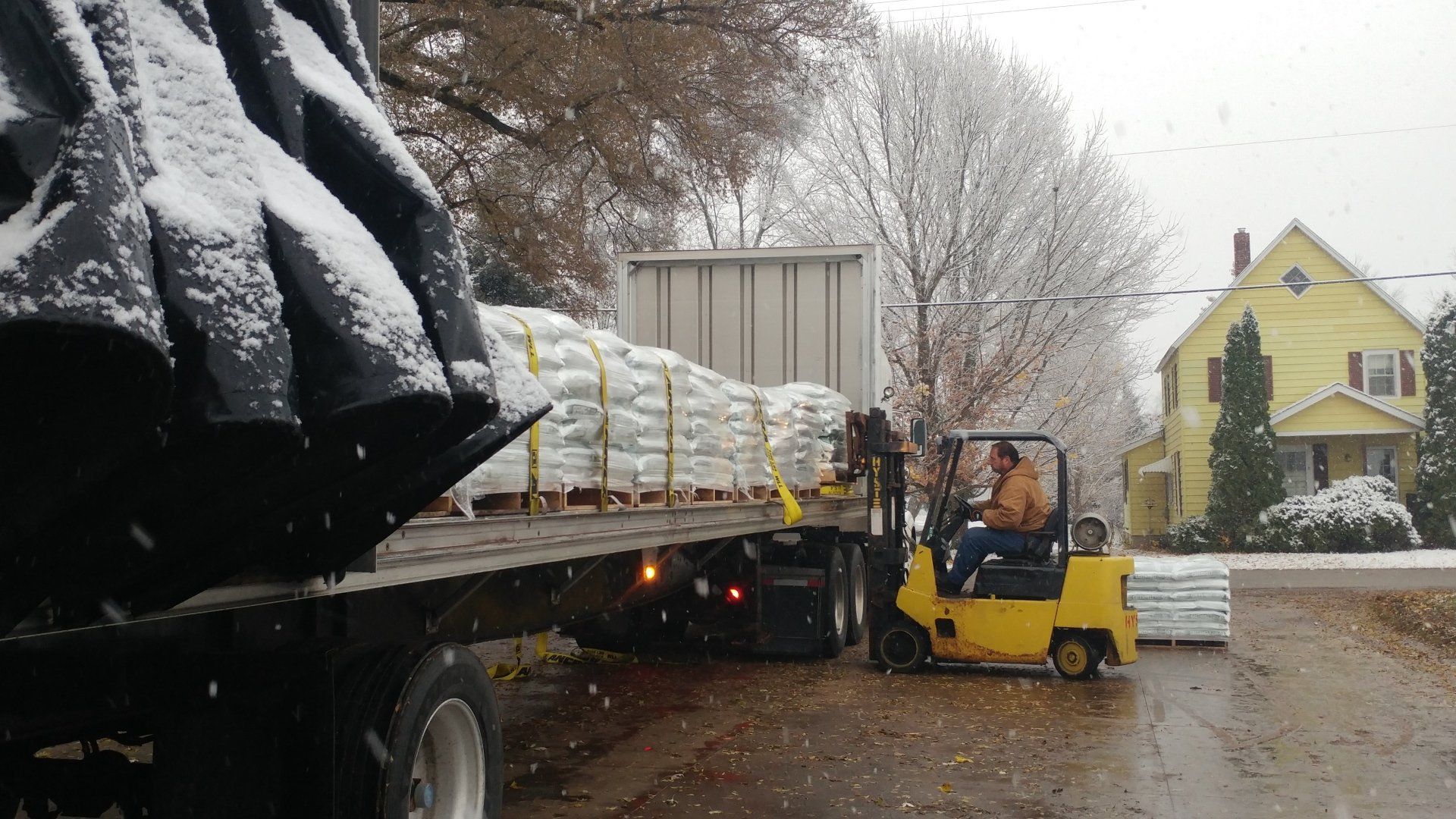 a man is driving a forklift on a snowy day