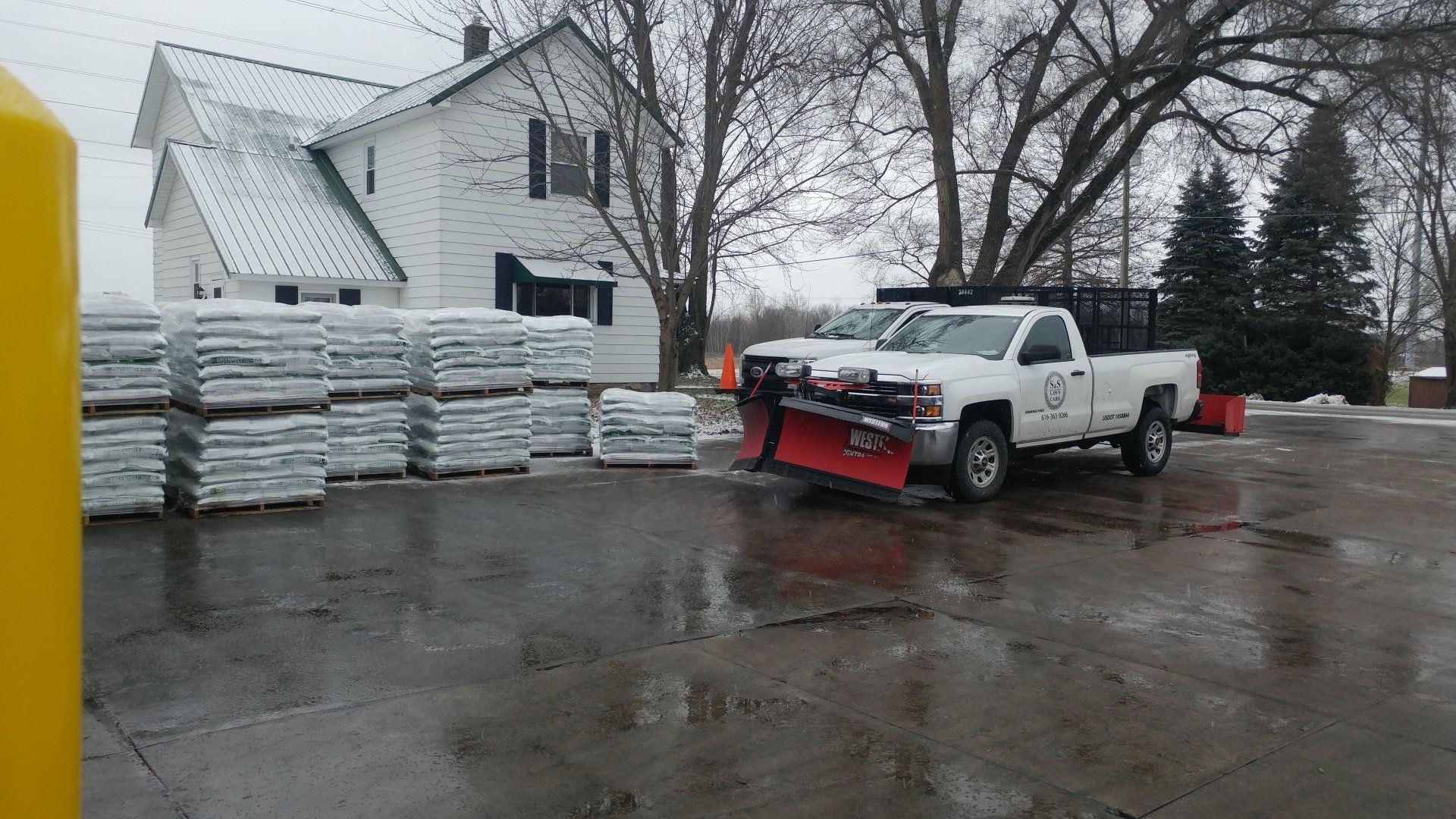 a snow plow is parked in a parking lot in front of a house