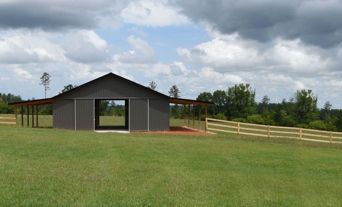 a barn is sitting in the middle of a grassy field