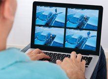 Man monitoring surveillance footage on his laptop