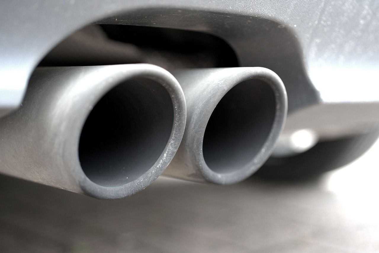 Dual exhaust pipes on a car, gray metal, close-up view.