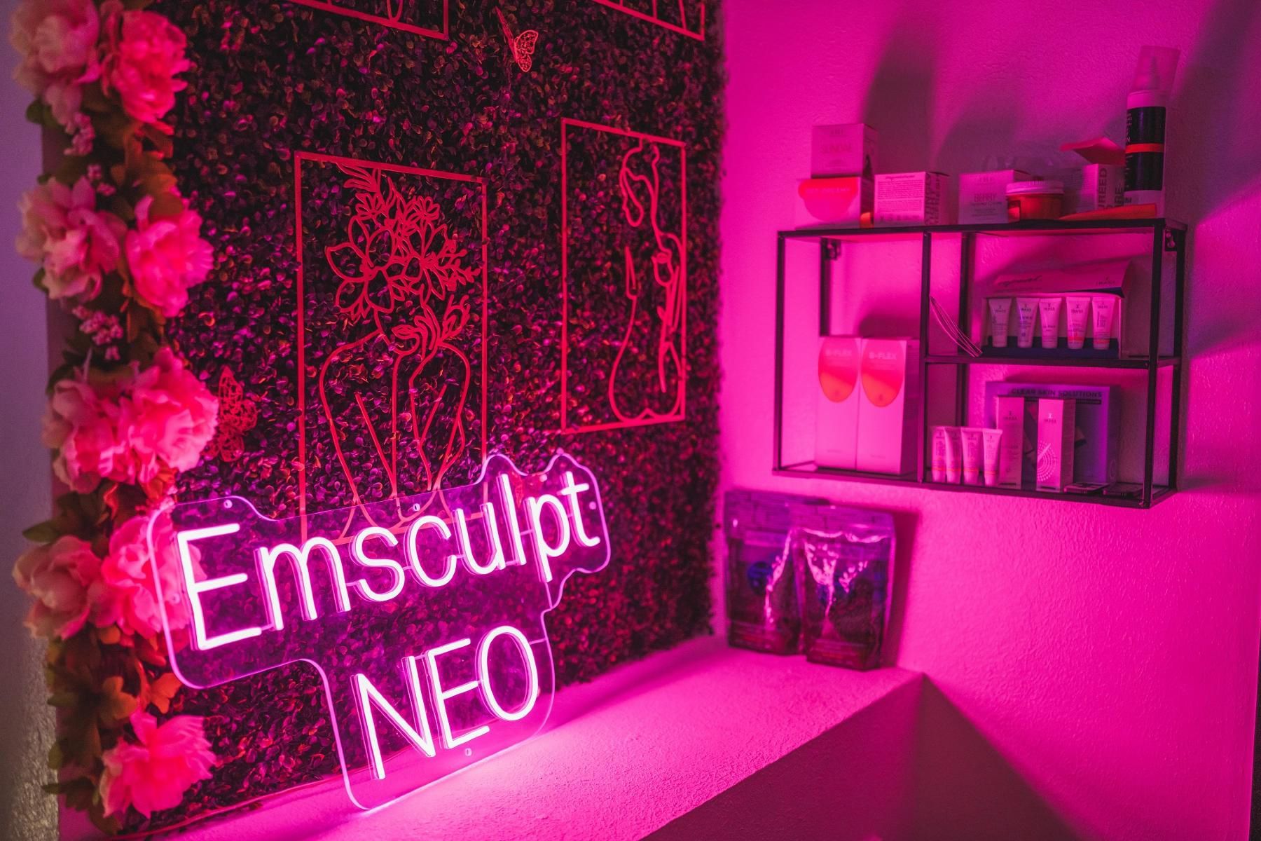 A neon sign is lit up in a room with pink lights.