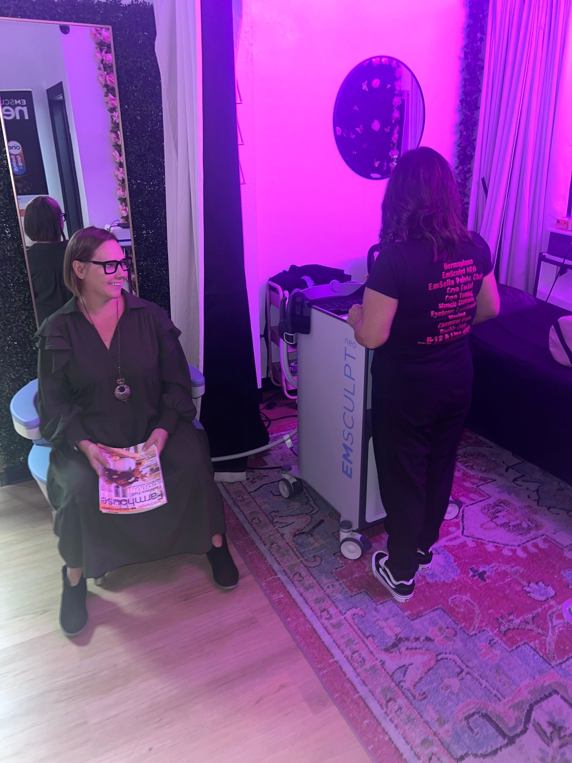 A woman is sitting in a chair in a room with purple lights.