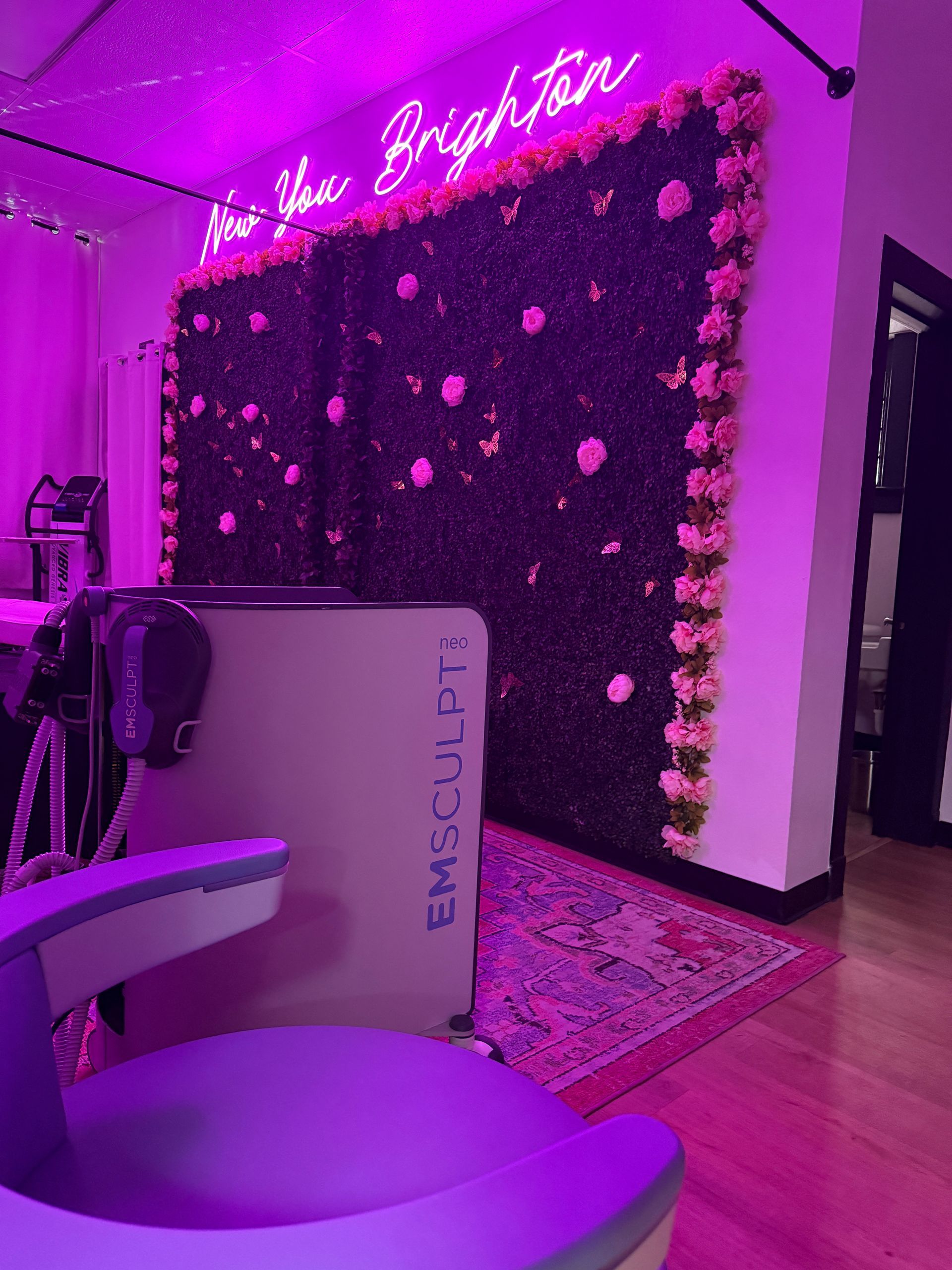 A purple wall with flowers and a sign that says