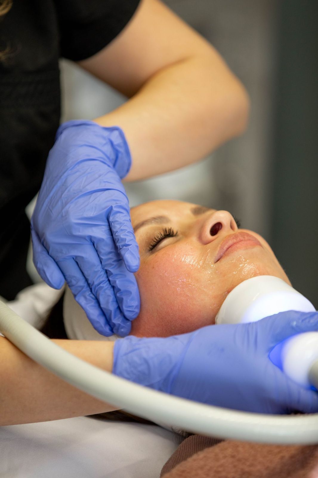 A woman is getting a facial treatment at a beauty salon.