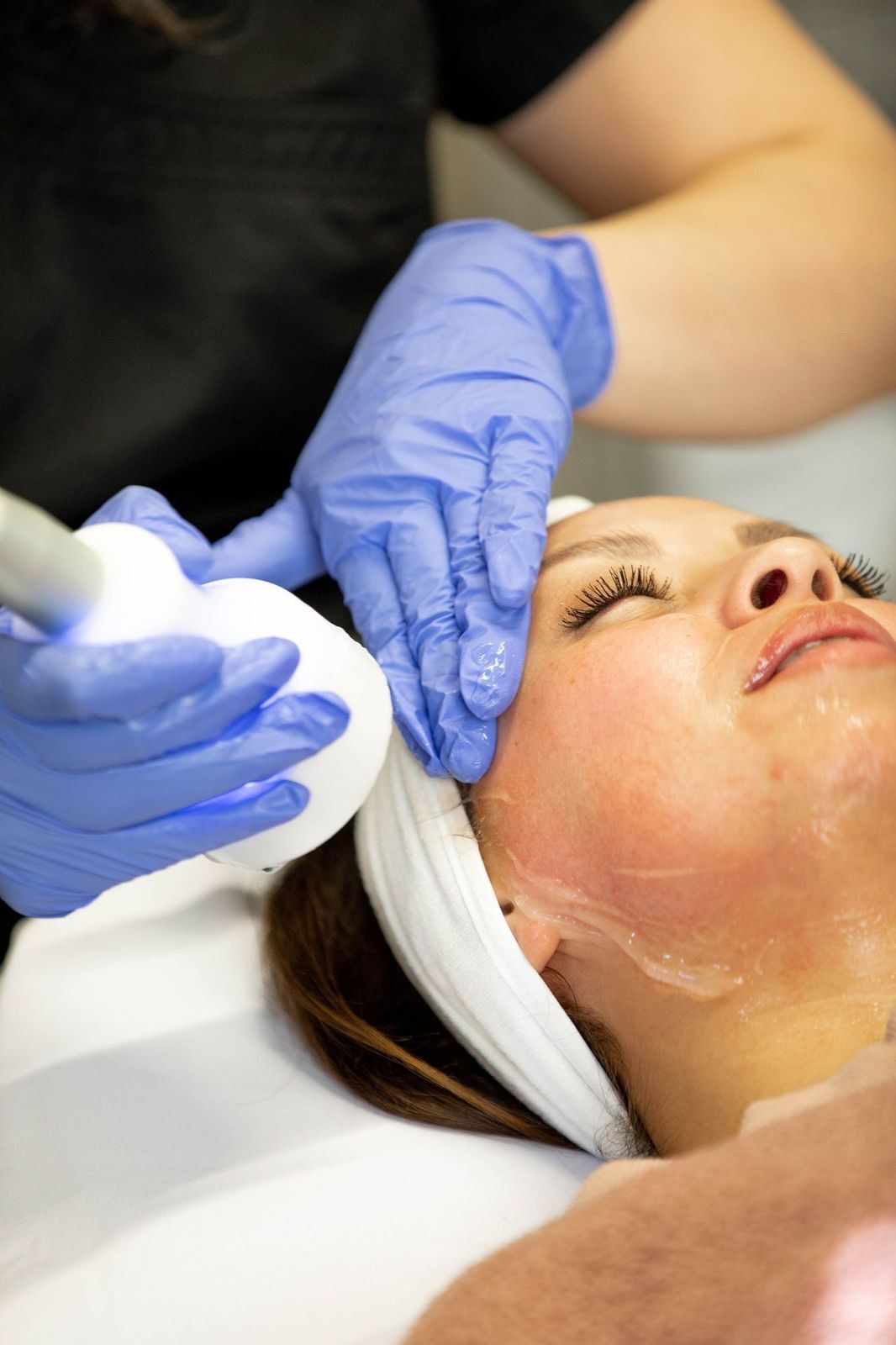 A woman is getting a facial treatment at a beauty salon.