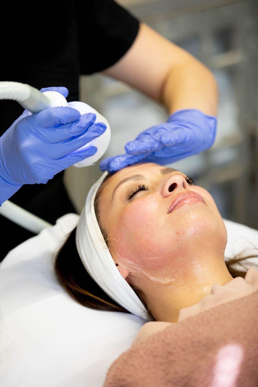 A woman is getting a facial treatment at a beauty salon.