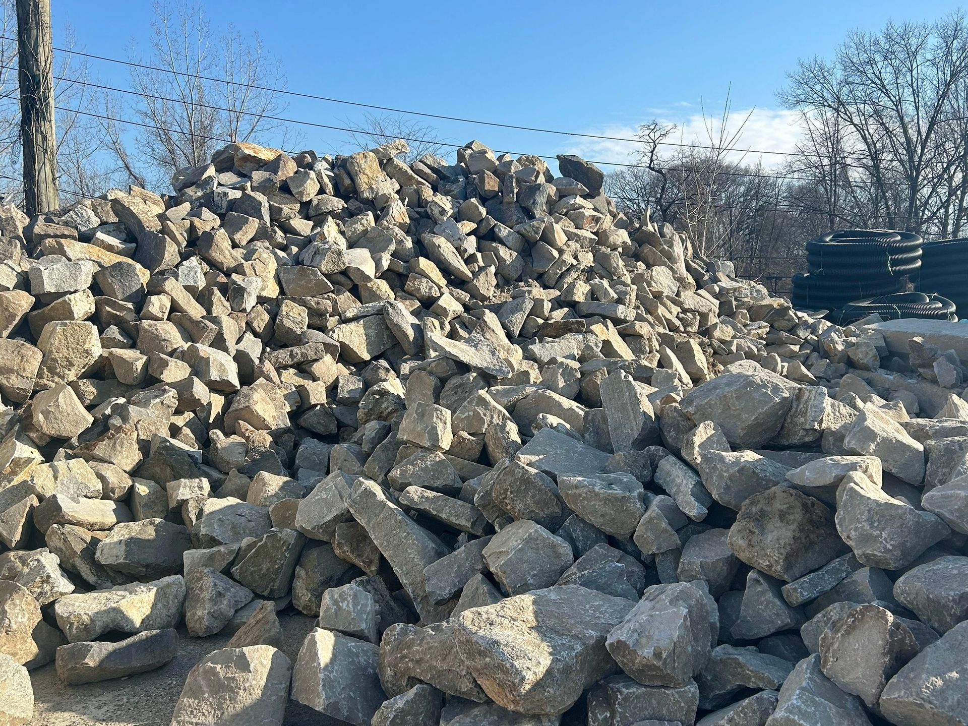 a pile of rocks is sitting on top of a dirt field .