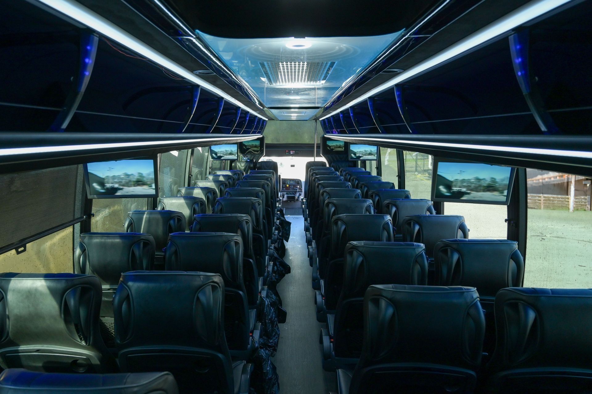 Interior of an empty luxury coach bus with dark seats and blue accent lighting