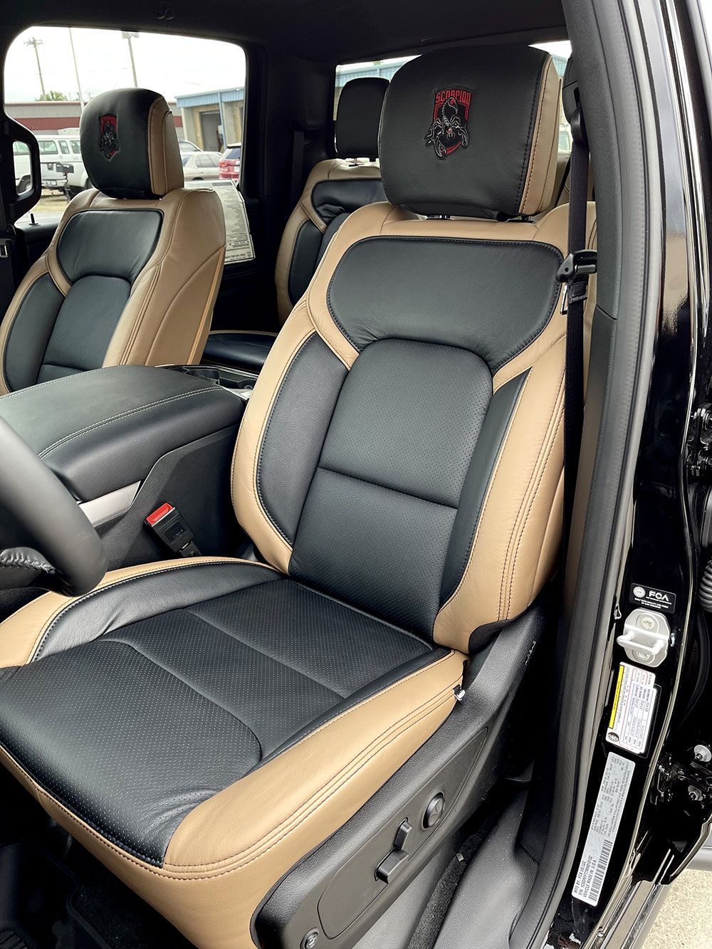 Black and tan leather truck seats with a red logo on the headrest.