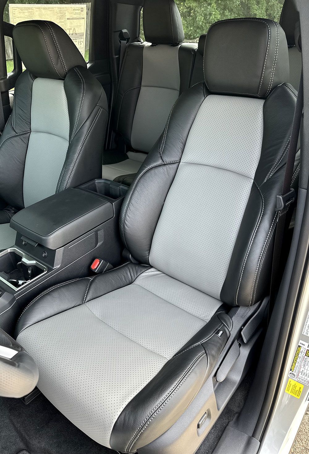 Gray and black leather car seats with diamond stitching. Center console visible.