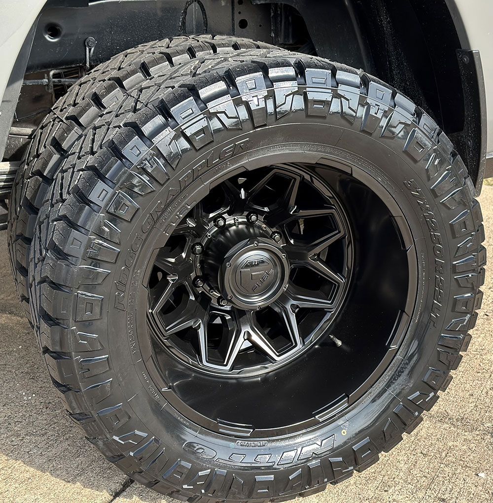Black truck tire with black rim.