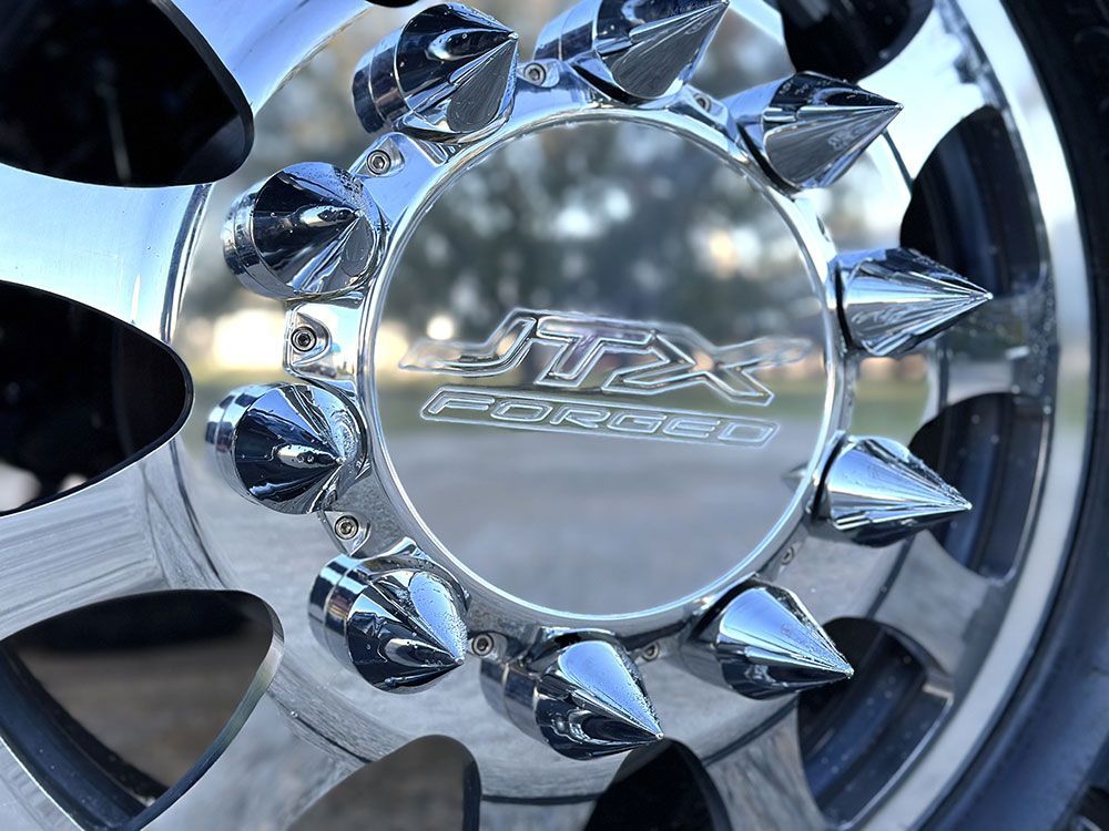 Chrome truck wheel with spiked lug nuts and 