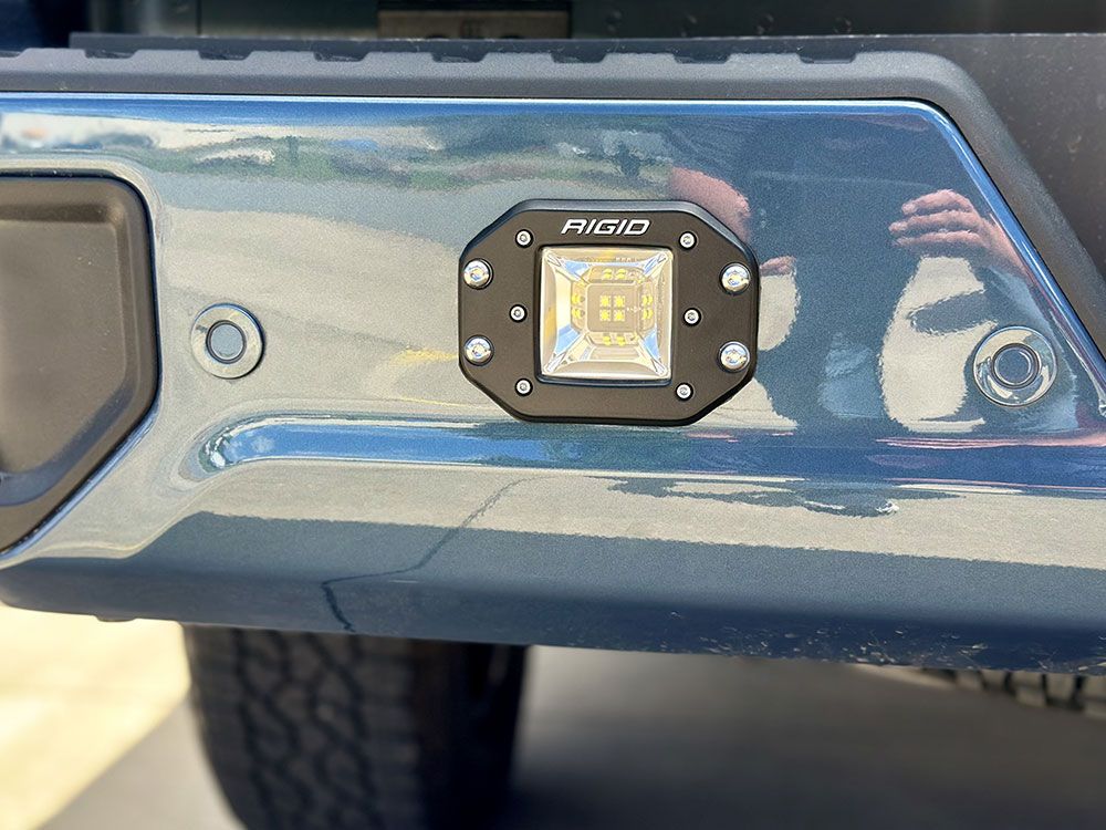 Black LED light on a blue vehicle bumper.