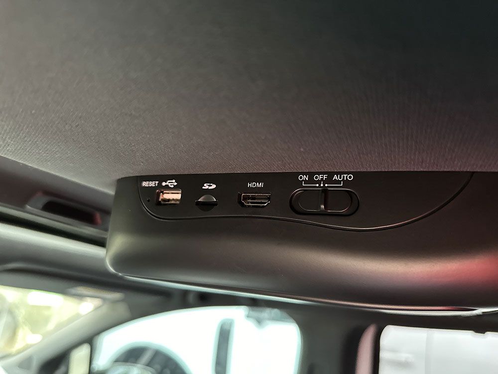 Black console on a car's ceiling with ports and switches: USB, SD card, micro USB, and power.