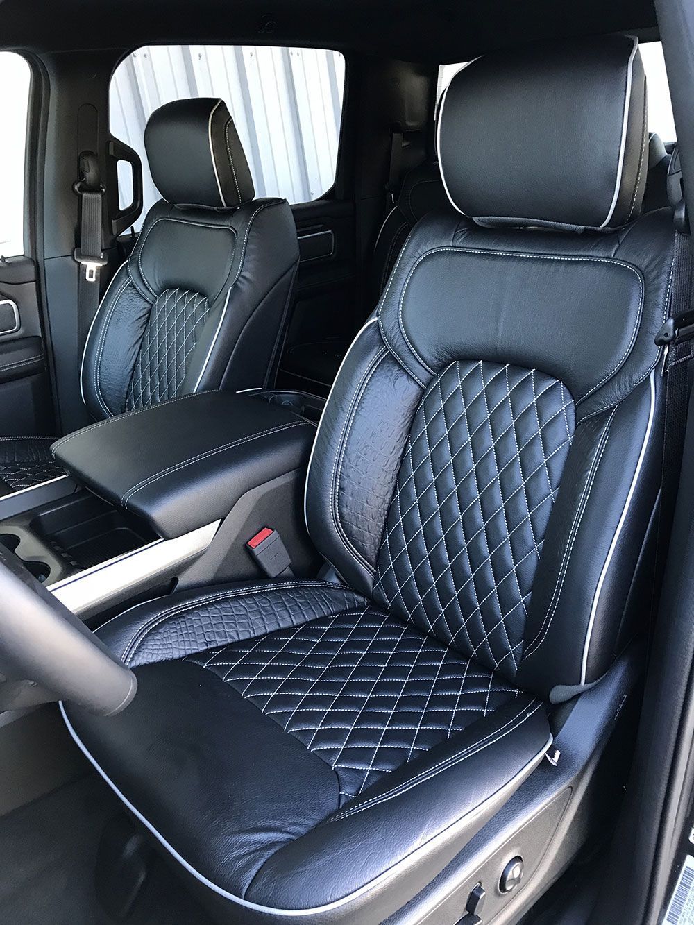Black leather truck seats with white stitching.