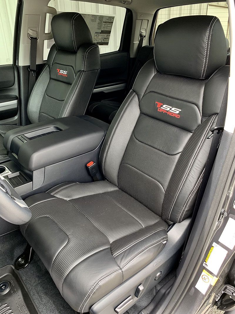 Black and gray leather truck seats with red “TRD” emblem, centered console, interior view.