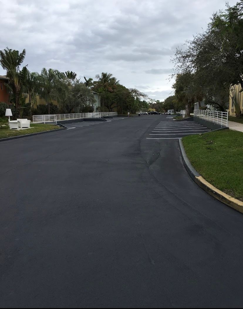 Newly paved street in residential area under cloudy sky.