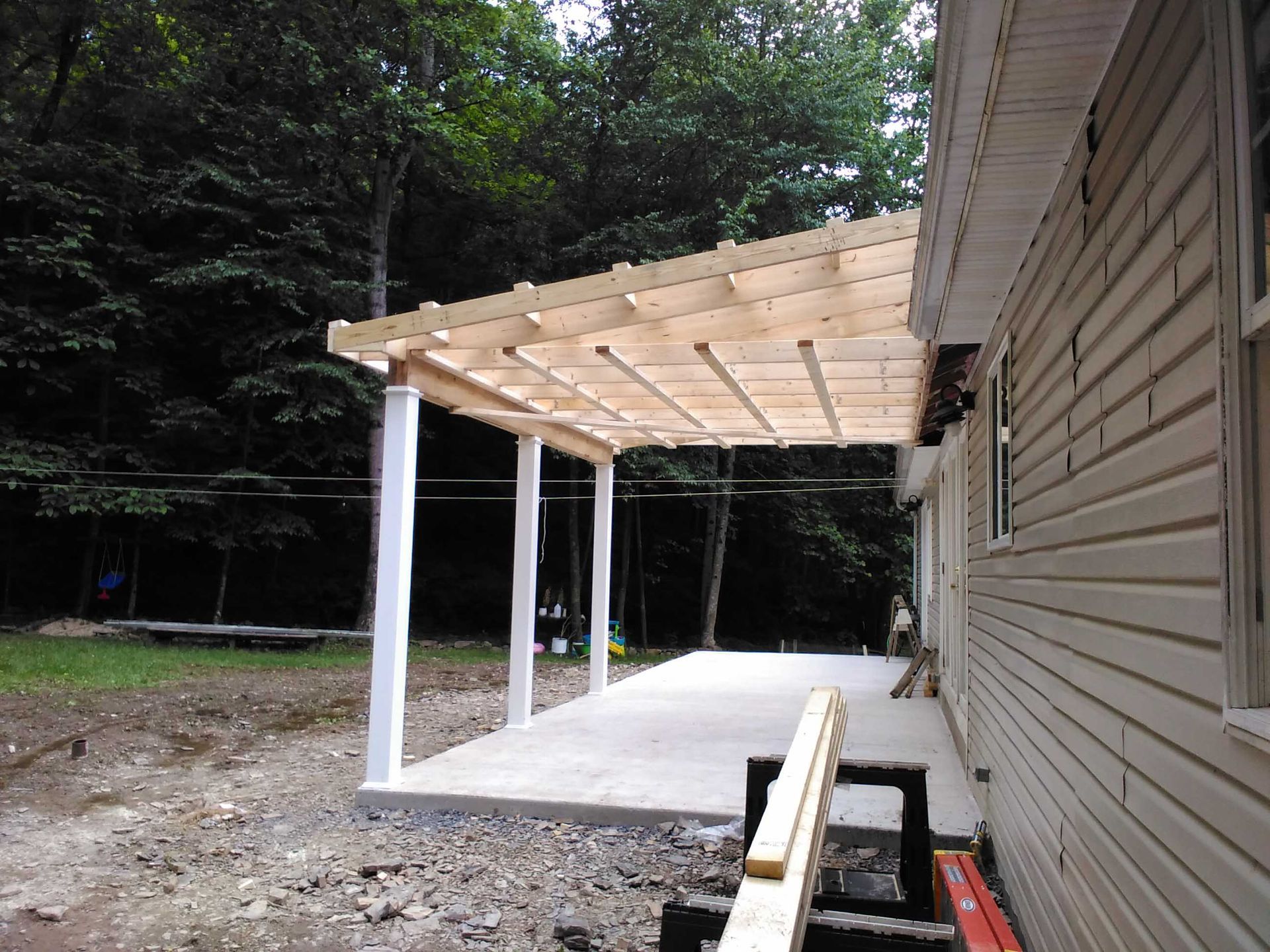 A white house with a wooden covered porch in front of it