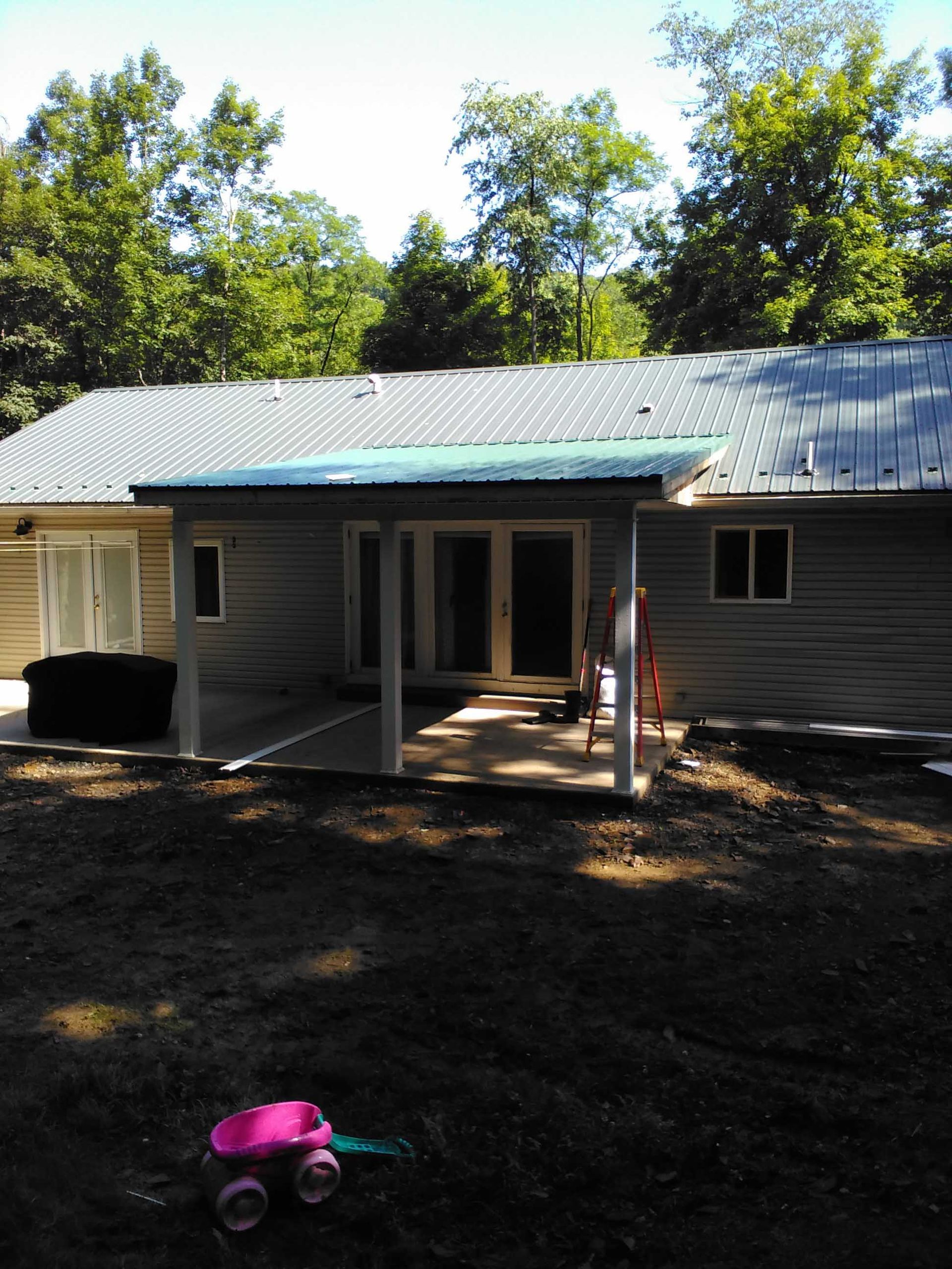 A pink toy truck sits in front of a house
