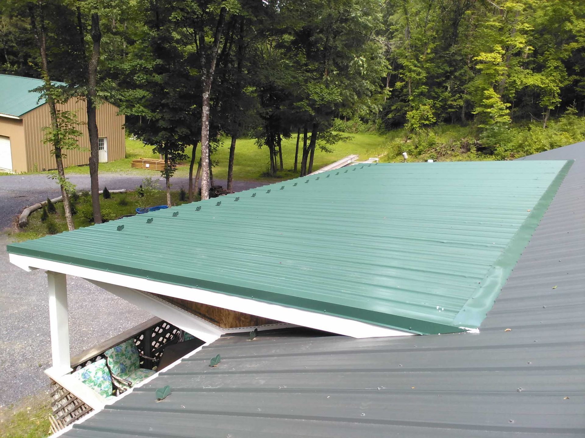 A green roof with a white trim is sitting on top of a house.