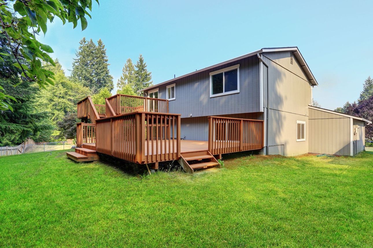 A large house with a large deck in the backyard.