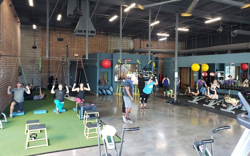 A group of people are doing exercises in a gym.