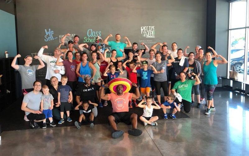 A large group of people are posing for a picture in a gym.