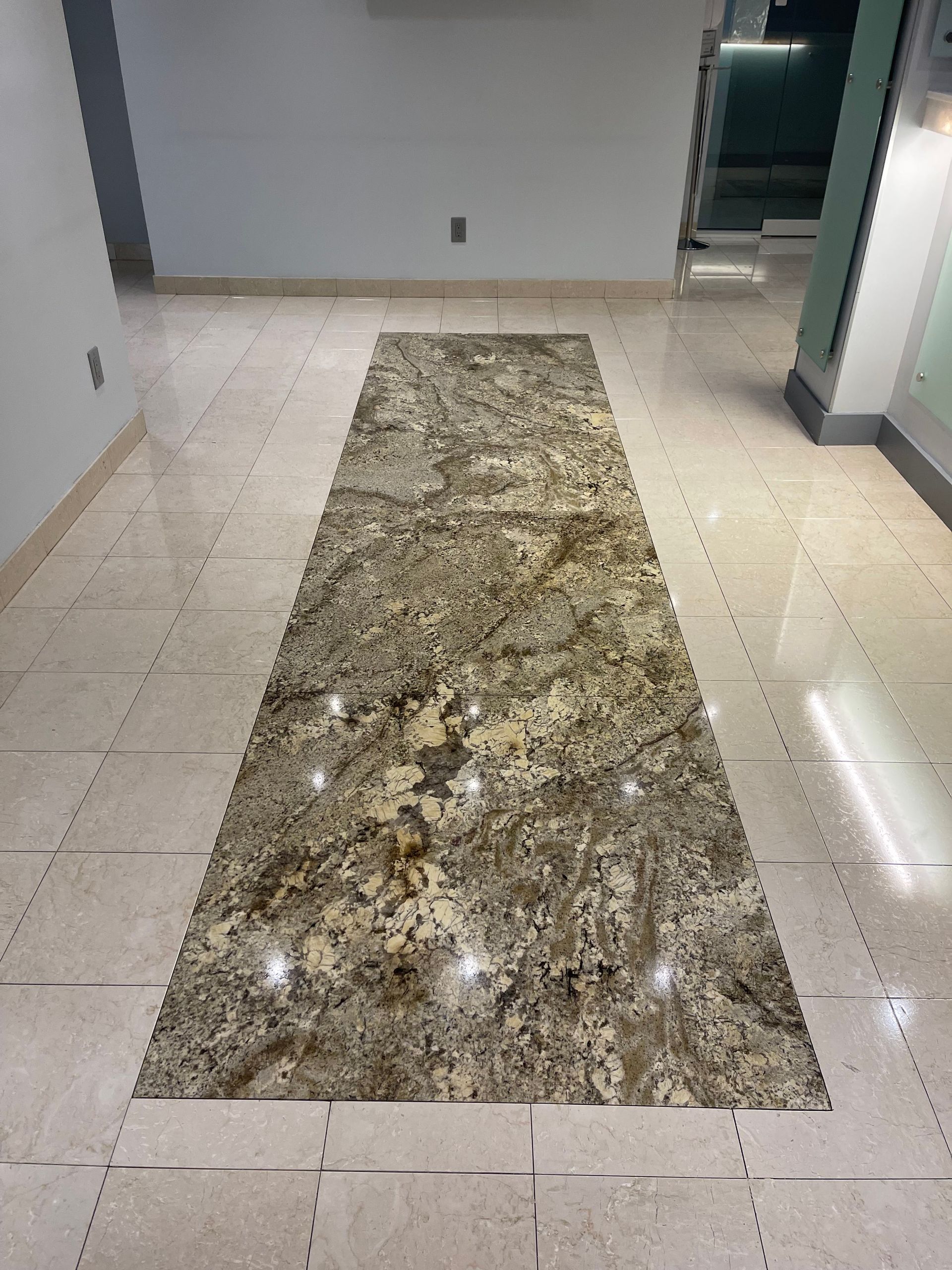 Hallway with granite runner on tiled floor, neutral colors.