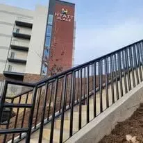 Black metal railing on outdoor staircase leading to a Hyatt Place building.