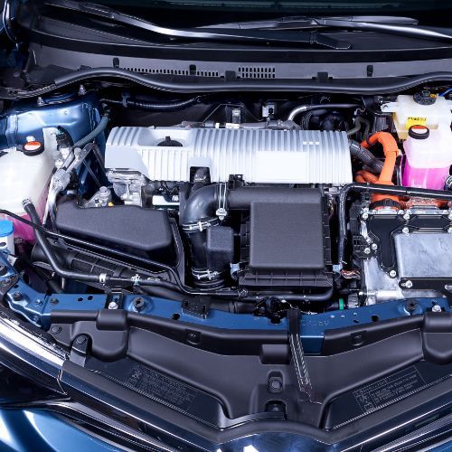 Car engine bay with black and silver components, orange cables, and a blue body frame top view