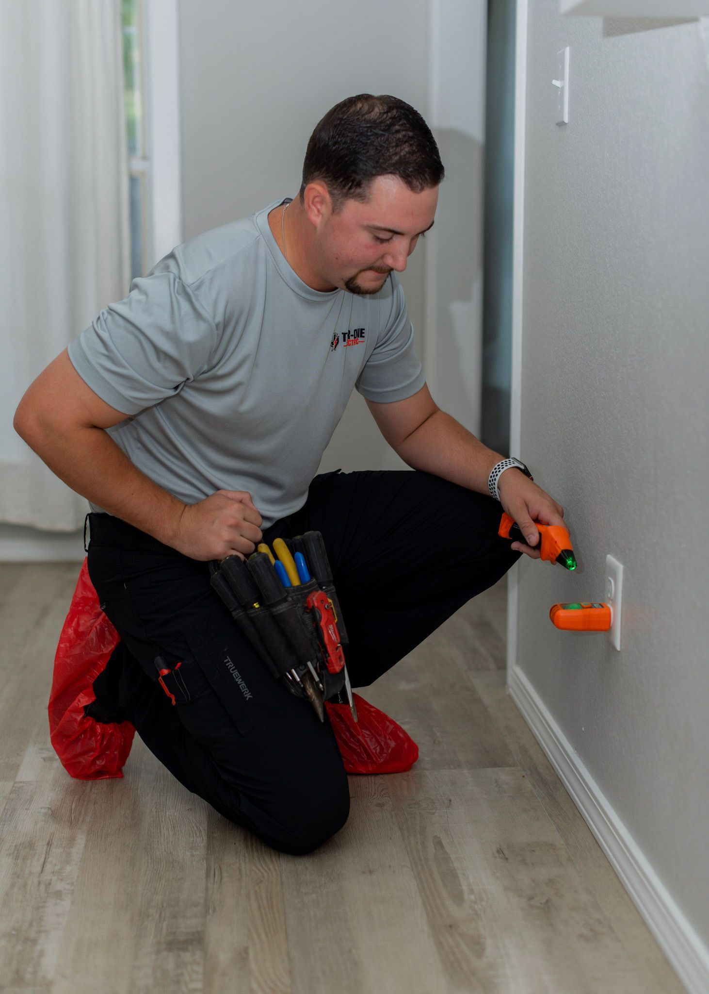 Tier One Electric technician testing a repaired electrical outlet in Copper Canyon, TX.