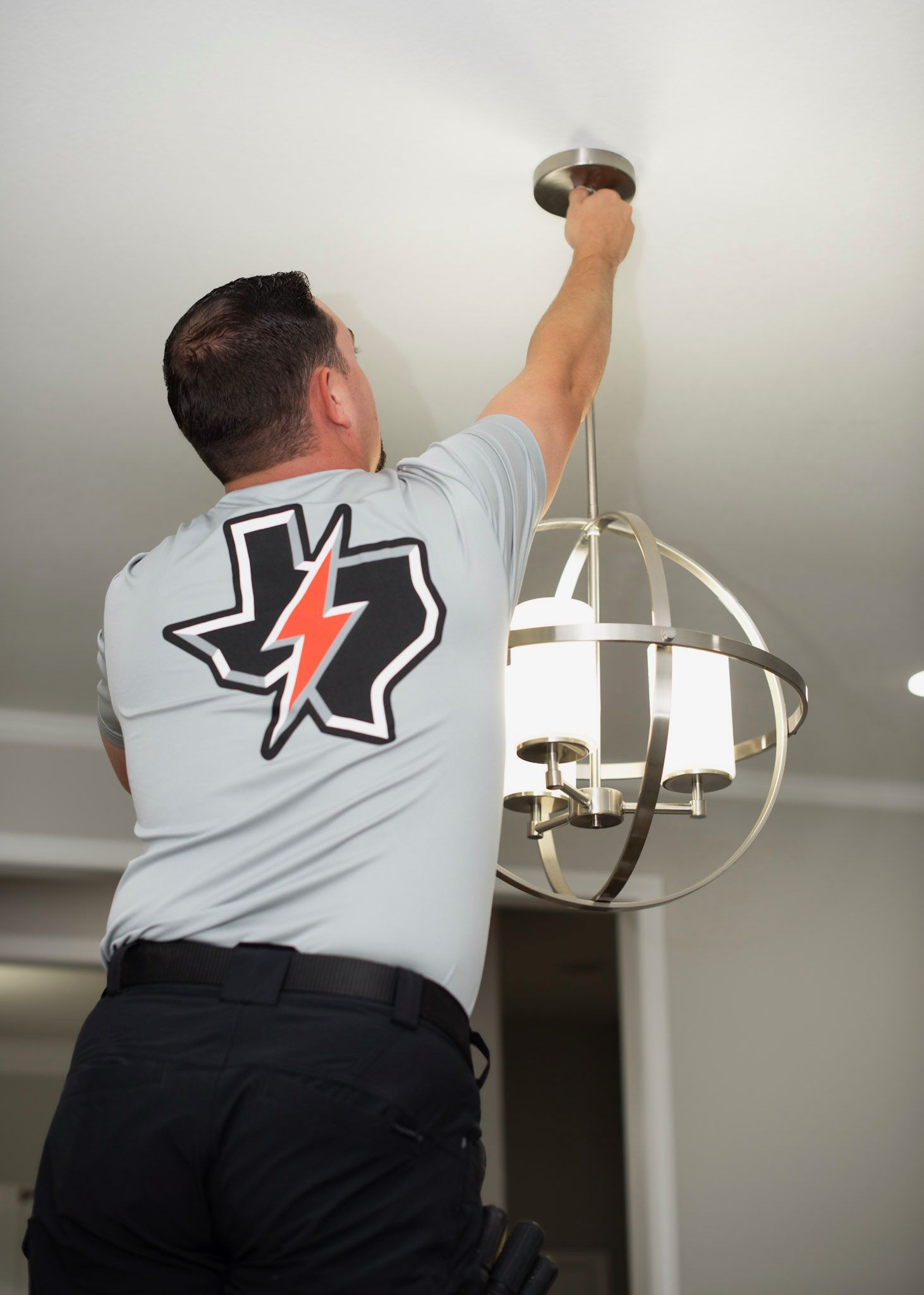 Person installing a ceiling light fixture with tools on a white ceiling