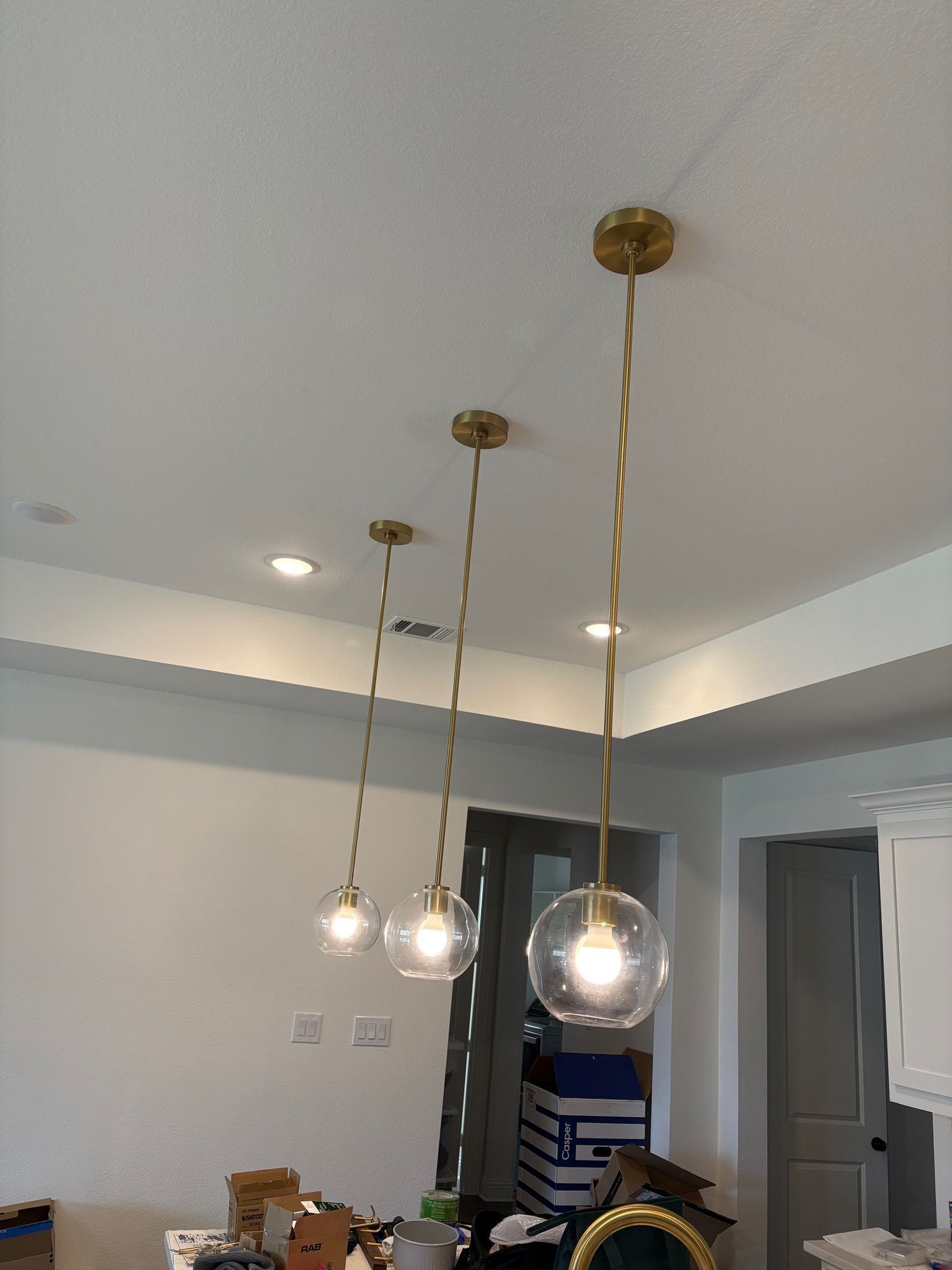 Three hanging pendant lights with glass globes in a modern dining room