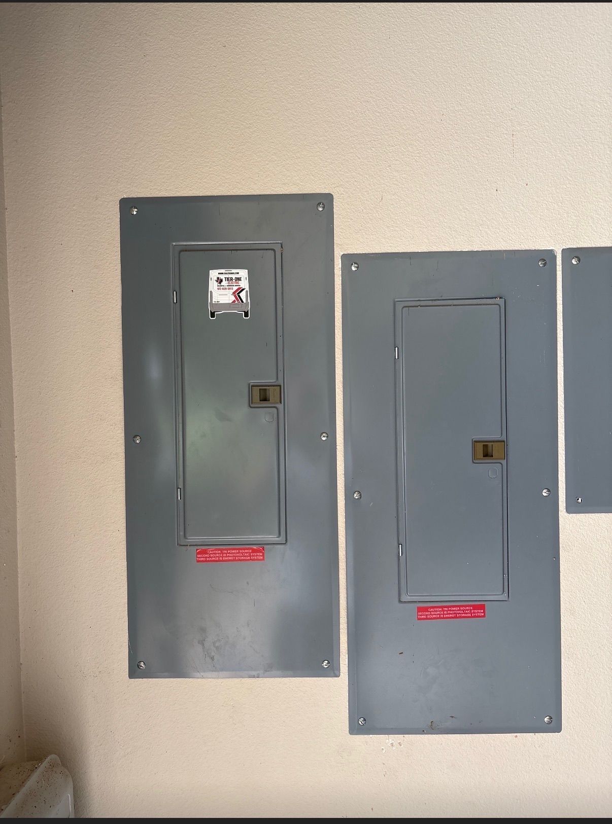 Two residential electrical panels installed side by side by Tier-One Electric.