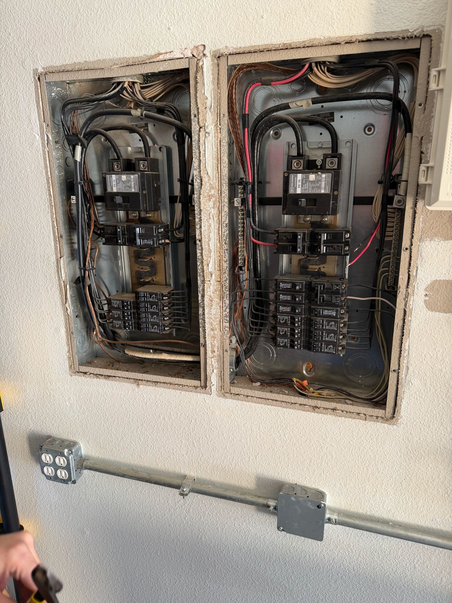 Two existing residential electrical panels exposed during a panel replacement project by Tier-One Electric.