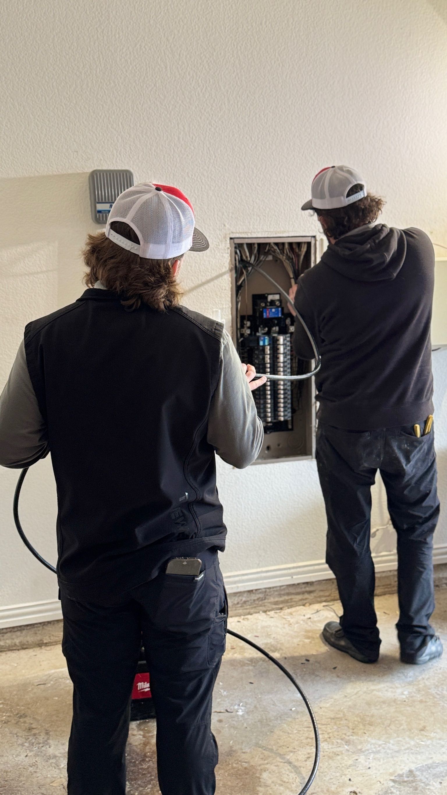 Tier-One Electric technicians servicing and updating a residential electrical panel.