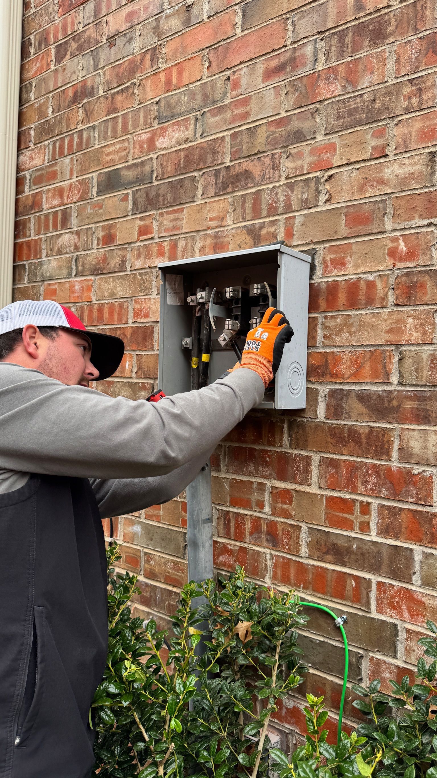 Tier-One Electric technician working on an exterior residential meter base installation.