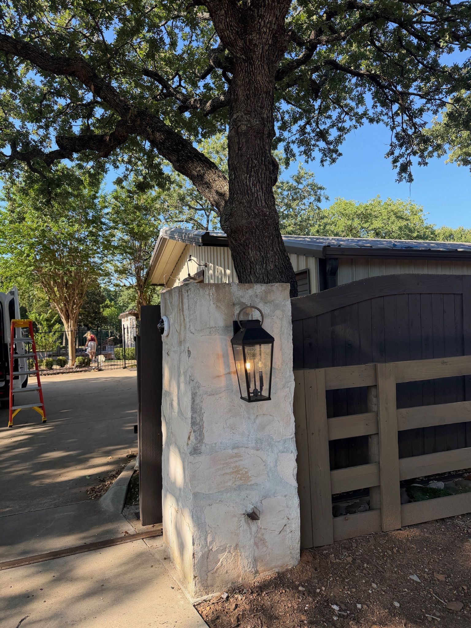 Outdoor coach light installed on a stone entry column by Tier-One Electric.