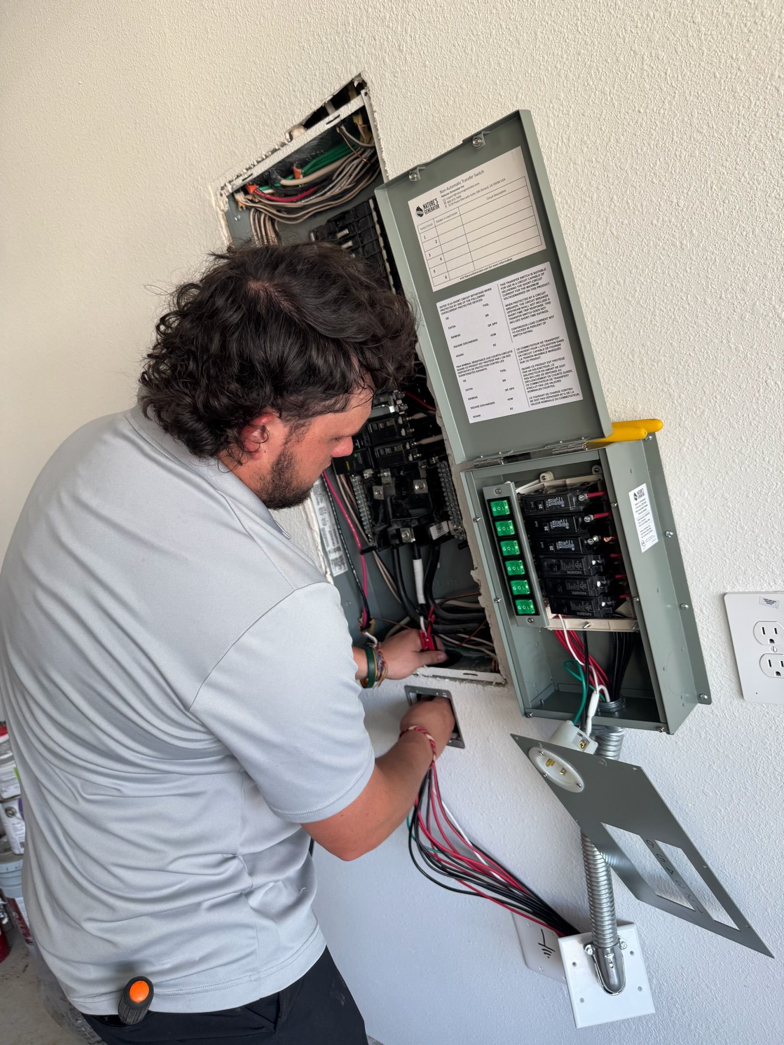 Tier-One Electric technician wiring a residential electrical panel and subpanel installation.