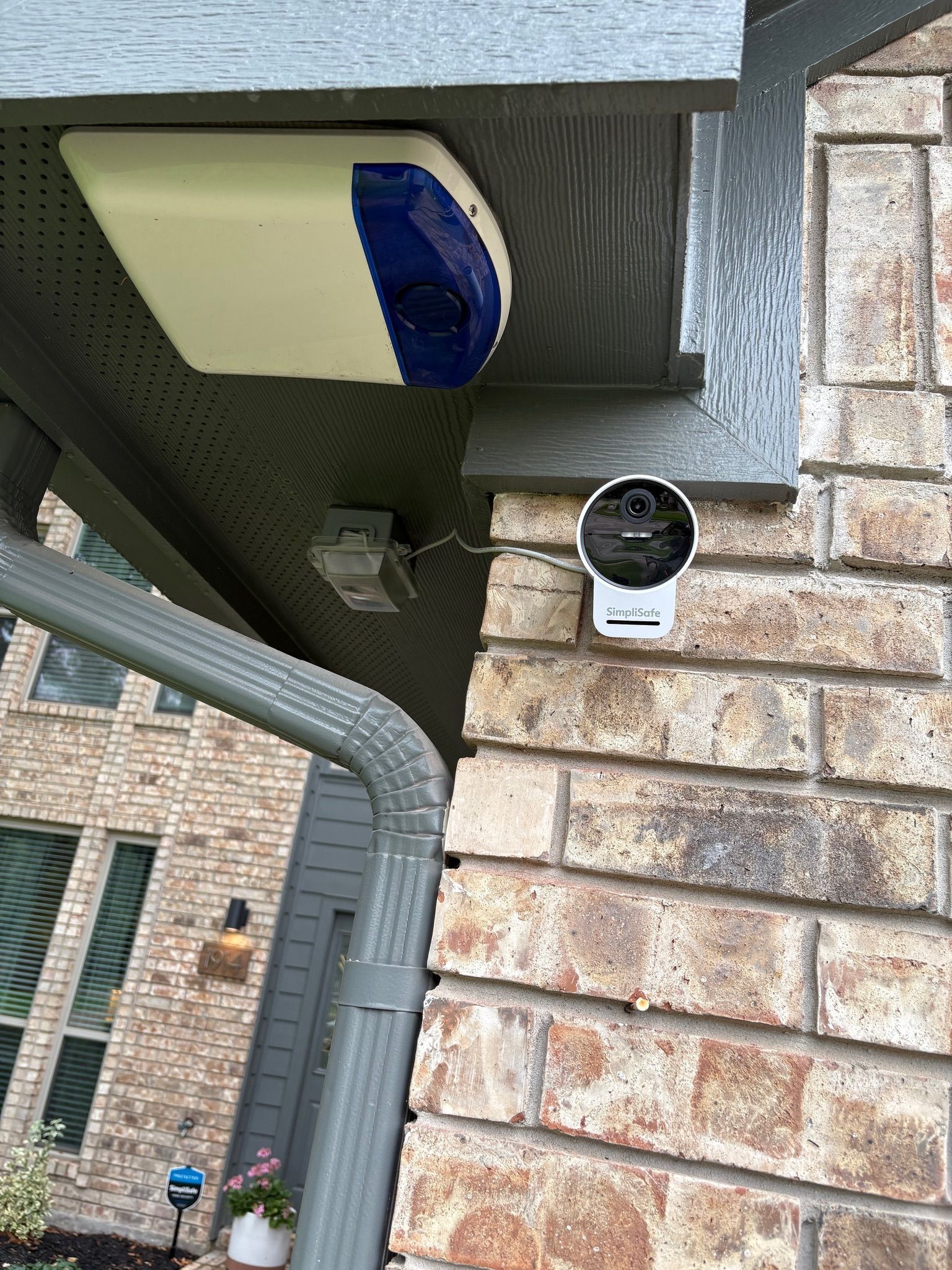 Outdoor soffit outlet installed near a home security camera by Tier-One Electric.