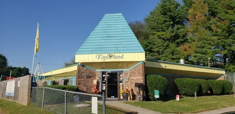 A building with teal roof and yellow trim. A sign says 