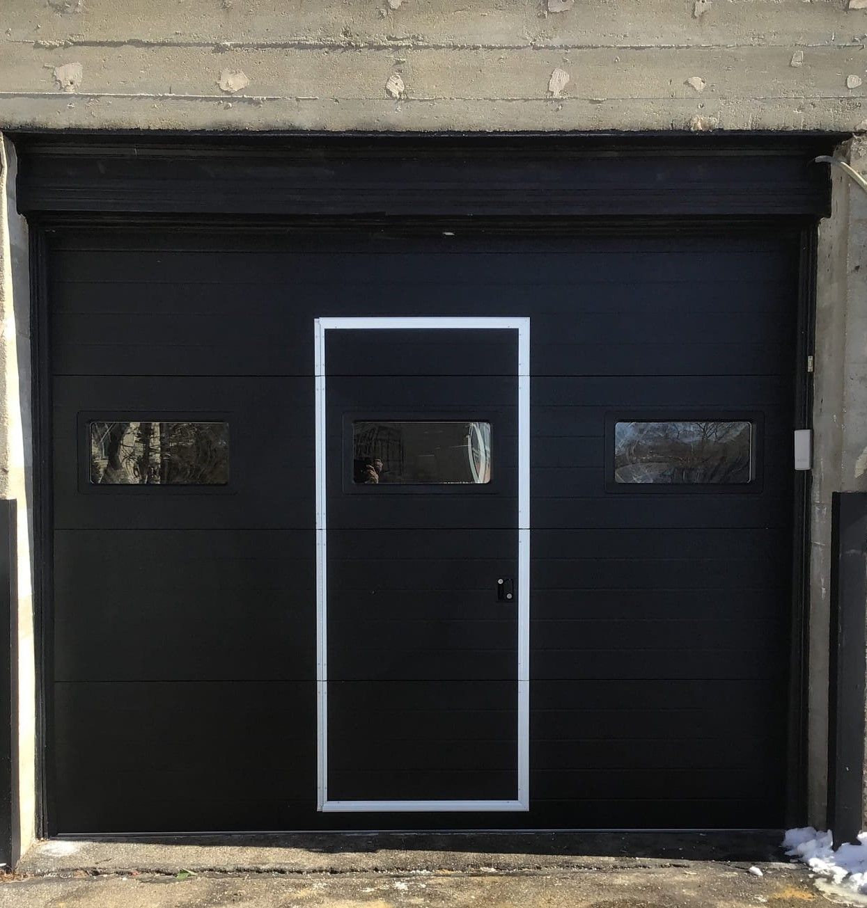 A black garage door with a white frame