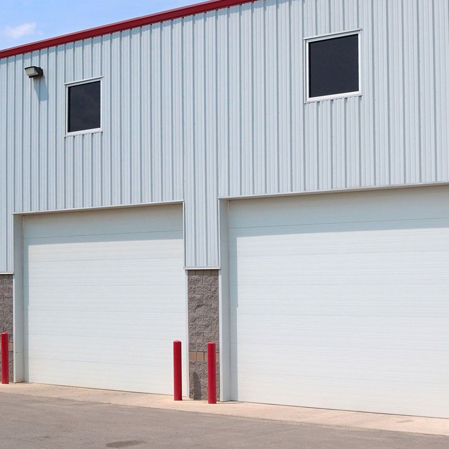 A white building with two garage doors and two windows