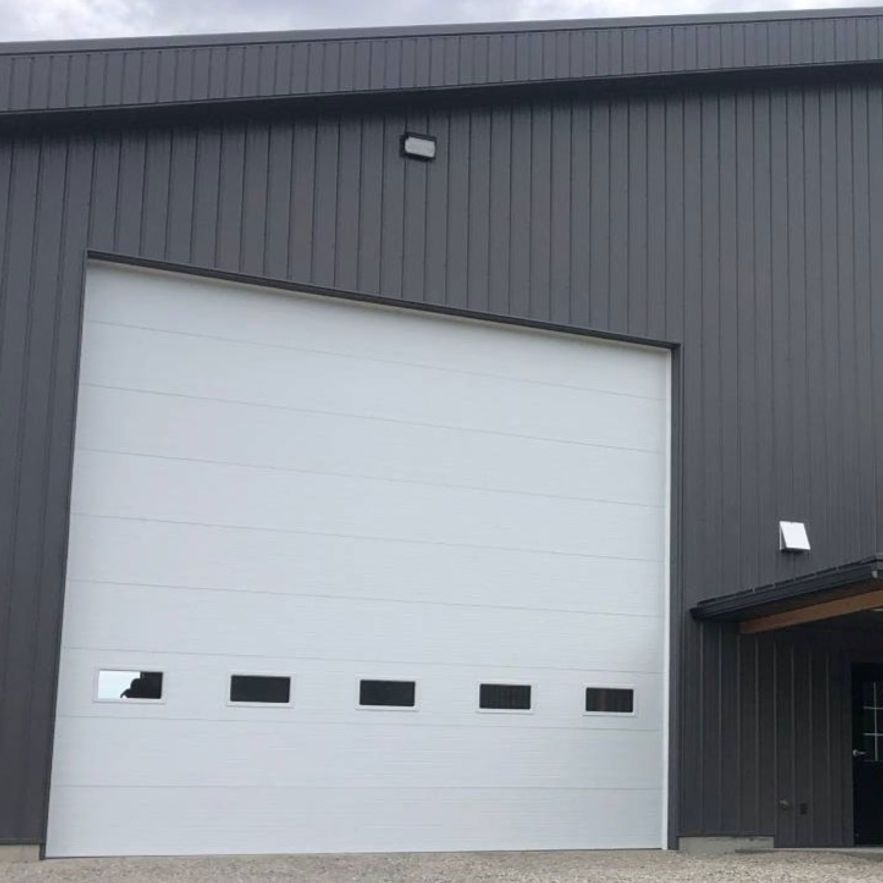 A large white garage door is on the side of a building.