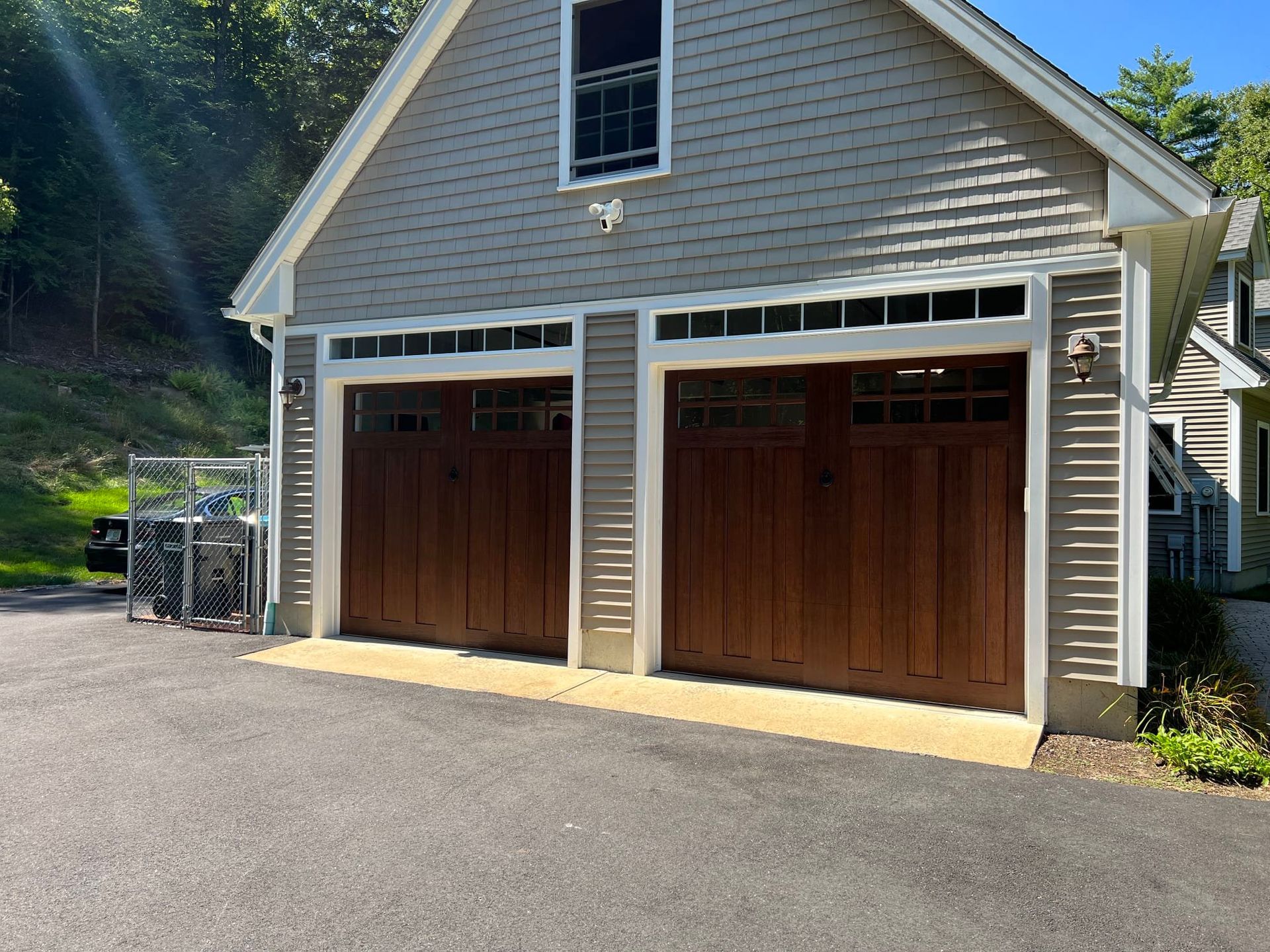 There are two garage doors on the side of a house.