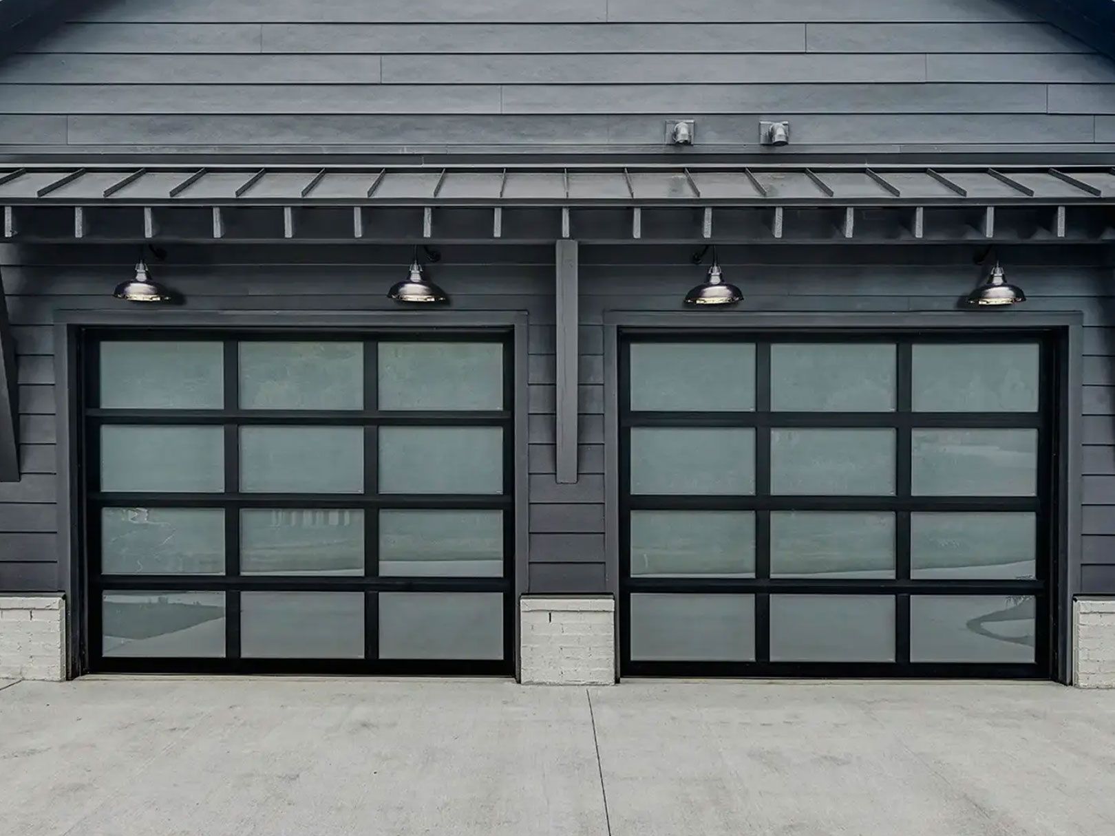 There are two garage doors on the side of a house.