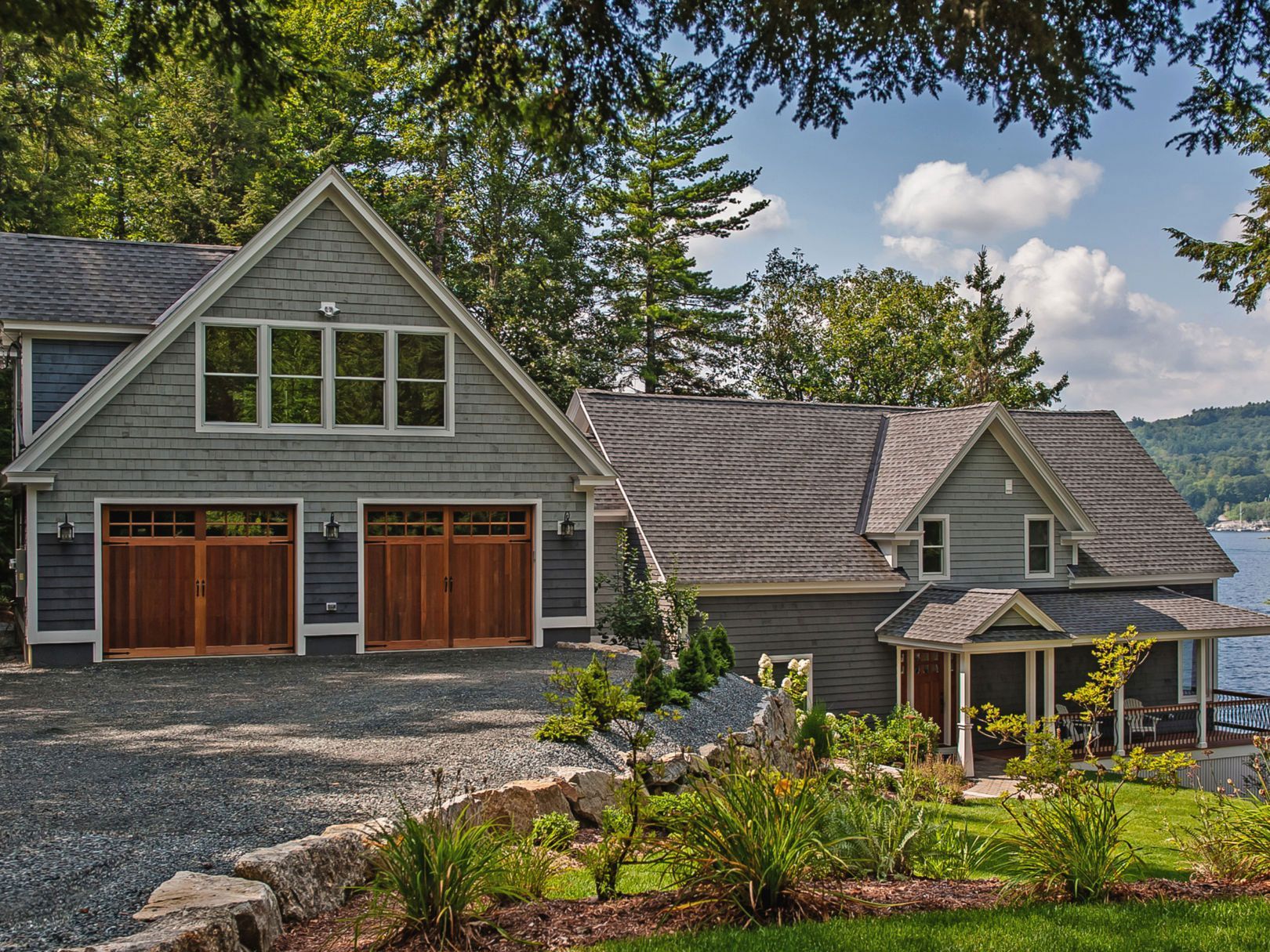 A large house with a garage next to a body of water