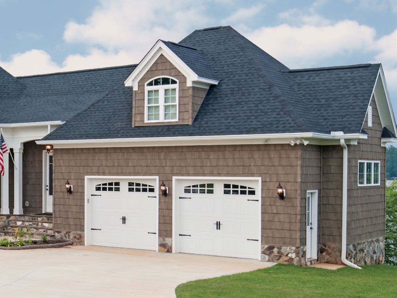 A house with three garage doors and a blue roof